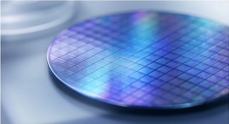 Macro photograph of a silicon wafer catching light with iridescent reflections